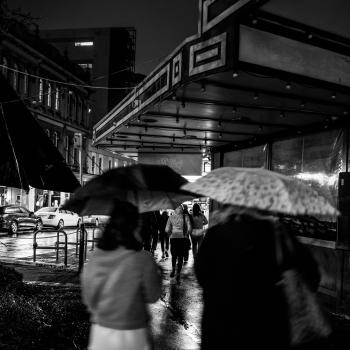 People in rainy night in the street black and white