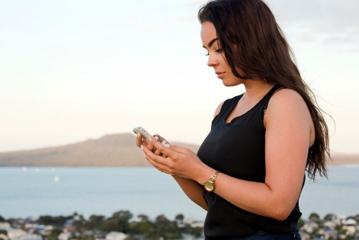 Pretty young Kiwi woman with mobile phone