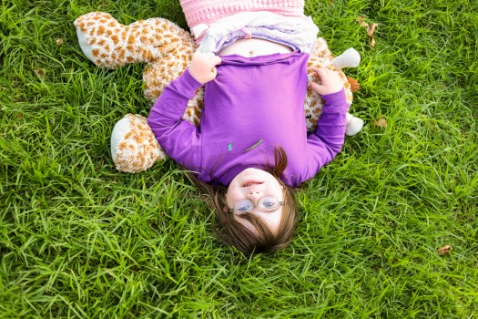 Girl with Down syndrome laying in the grass
