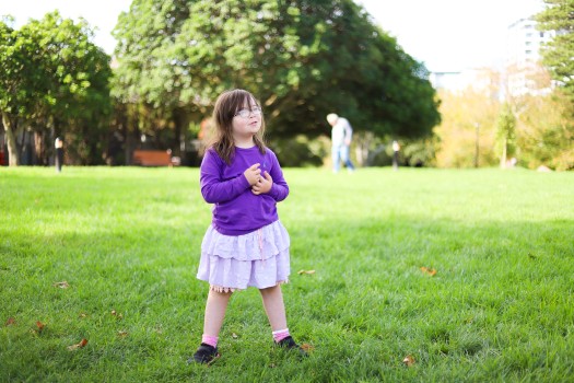 Little girl with Down syndrome in a garden