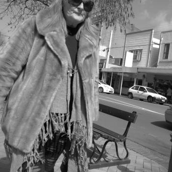 Old lady in a poncho and fur coat in the street in Newtown monochrome