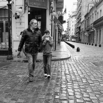 Father and son walking on cobbled street winter black and white
