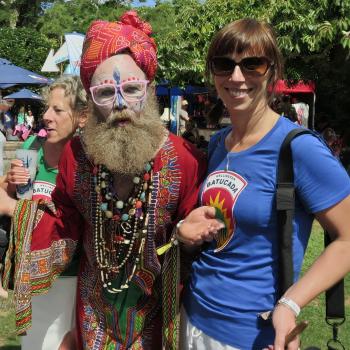 Indian attired man with women wearing blue and green shirt at WOMAD festival