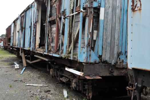 Damaged old wooden blue freight bogie on tracks