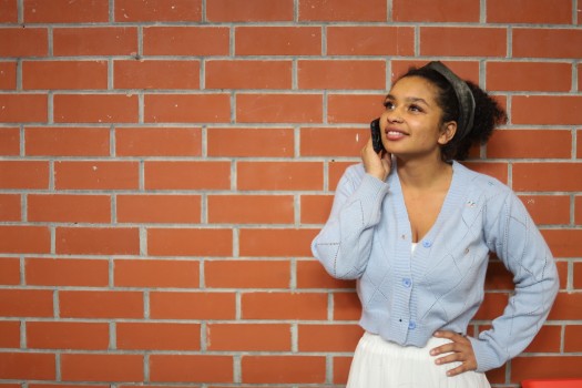 Girl talking on phone in front of wall