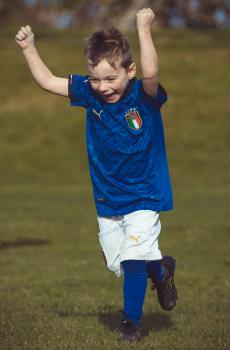 Little boy cheering at Little Dribblers football match