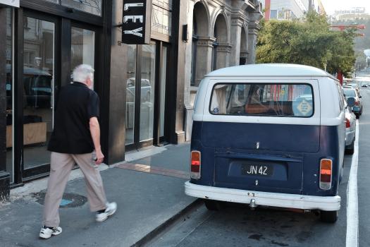 Old blue and white VW bus parked in the street