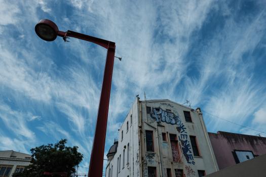 Partly cloudy sky and a graffitied building Cuba Street