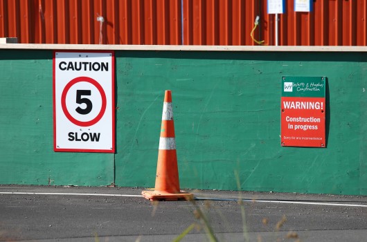 Construction zone signs on green wall