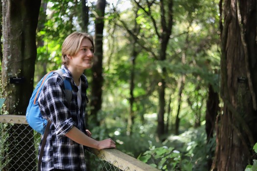 A smiling person in a forest
