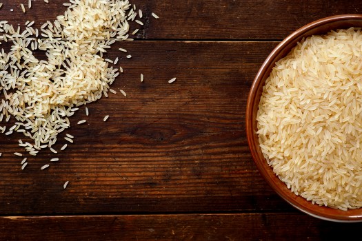 Bowl of rice on wooden background