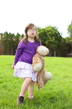 Little girl with Down syndrome in a yard