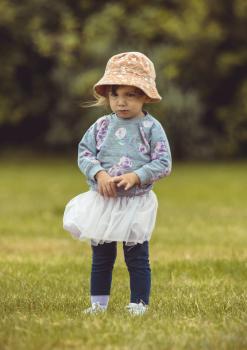 Girl wearing floral hat sweater skirt and pants - Little Dribblers