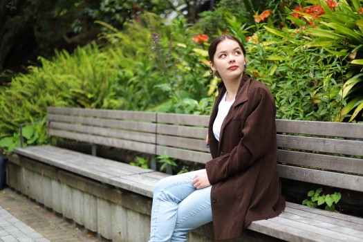 Young lady sitting on a bench in a park