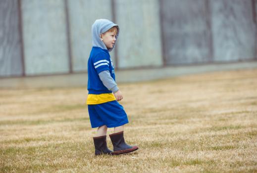 Little boy in blue outfit and high boots at Little Dribblers soccer contest