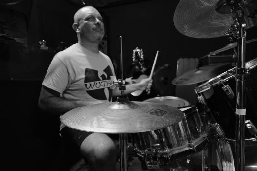 Drummer playing drums for band "Vietnam" monochrome