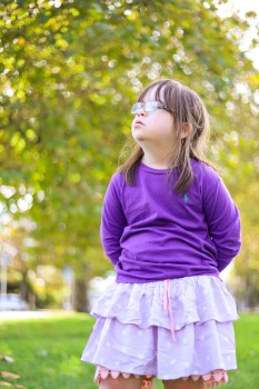 Girl with Down syndrome in purple polo shirt