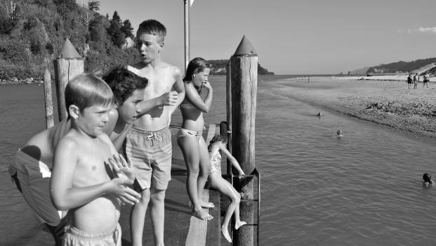 Boys and girls in swimsuit on a pier at Whanagamata black and white
