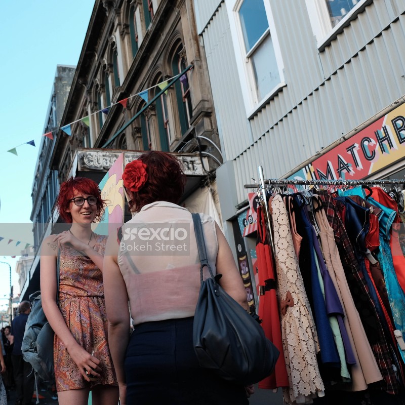 Two redhead women having a converstion at the market