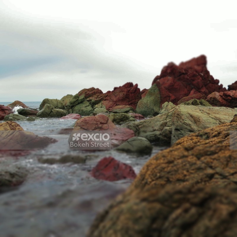 Natural red rocks and sea waves at Owhiro Bay