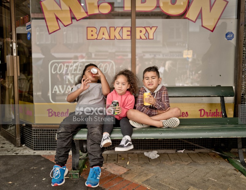 Cute kids on a bench drinking soda at Newtown festival 2021