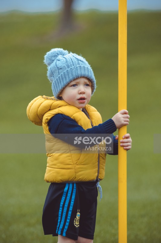 Girl in yellow vest holding a yellow pole