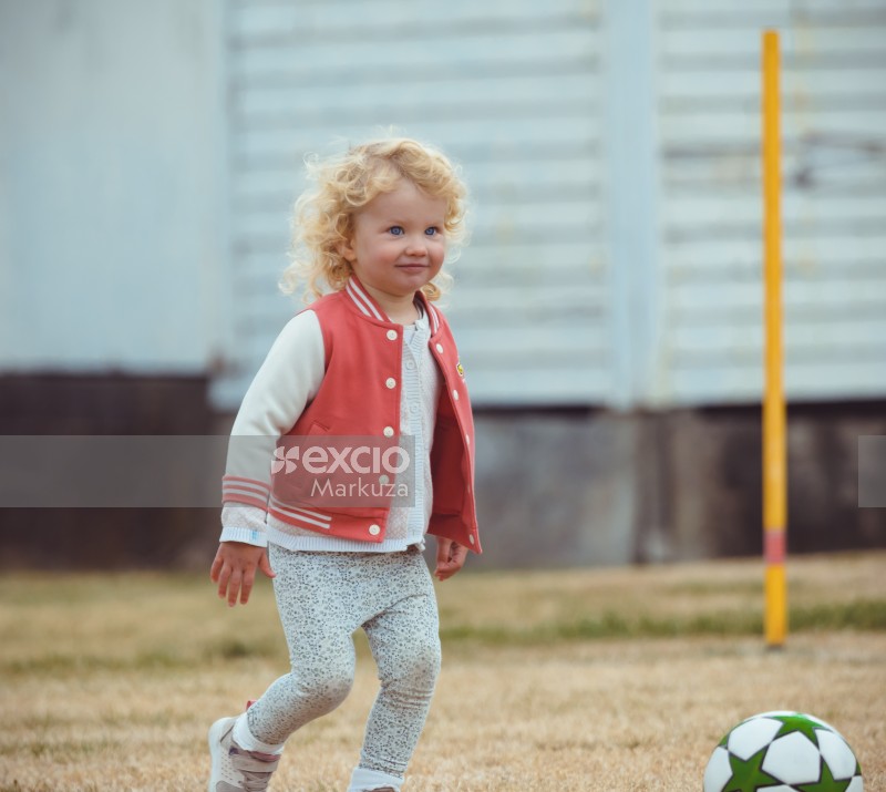 Blue eyed blonde curly haired girl at Little Dribblers football match