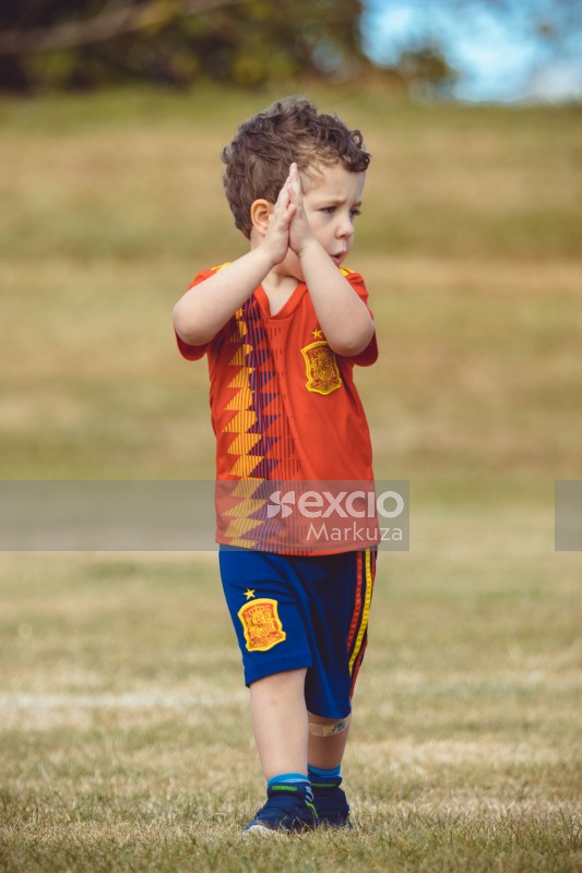 Boy in Manchester United kit clapping at Little Dribblers football match
