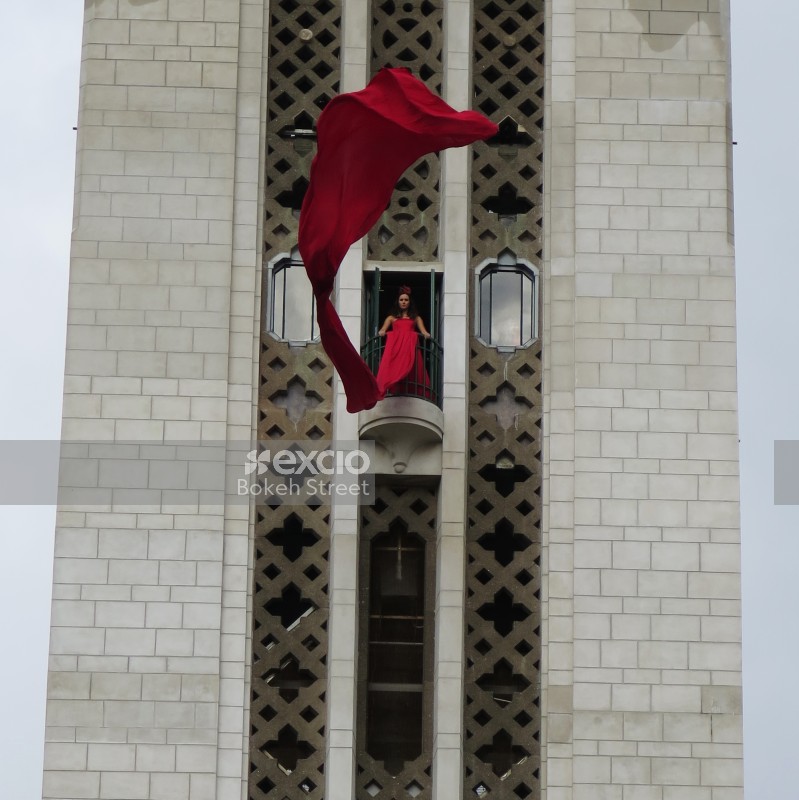 Woman in a tower waving her long red dress