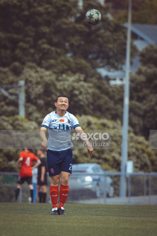 Smiling asian player await falling ball - Sports Zone sunday league