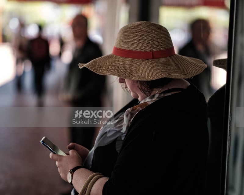 Woman wearing a hat typing a message