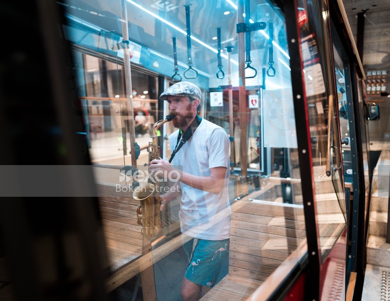 Musician reflected in cable car window