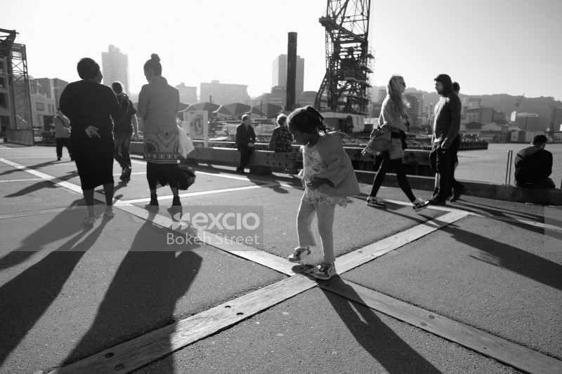 People gathered on a wharf enjoying a windy sunny day monochrome