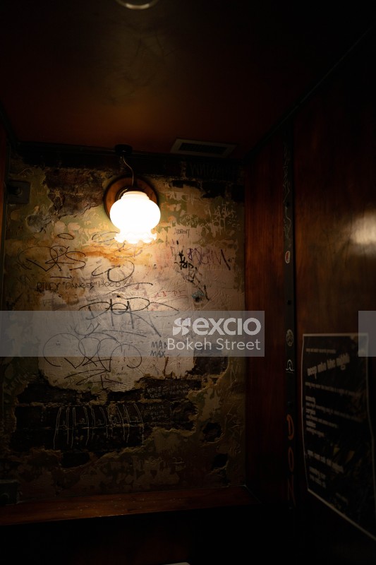 Graffiti on a tarnished wall in a dimly lit room