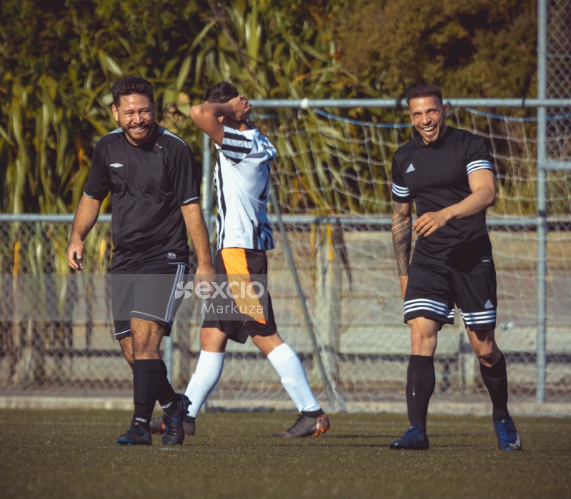 Two football team players walking and laughing - Sports Zone sunday league