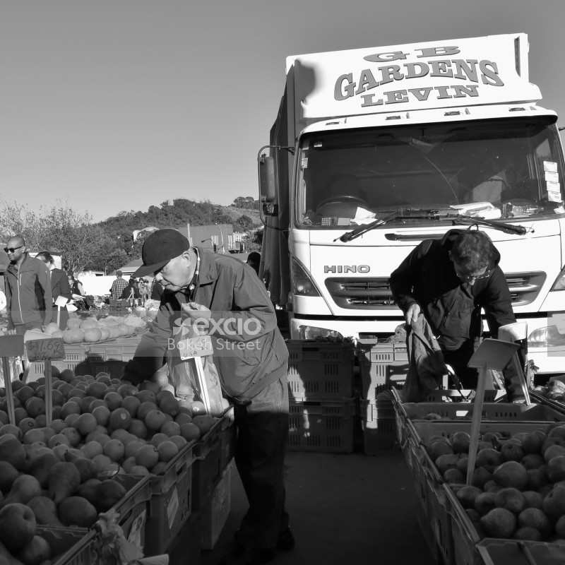 Customers buying fruit & vegetables at the local produce market monochrome