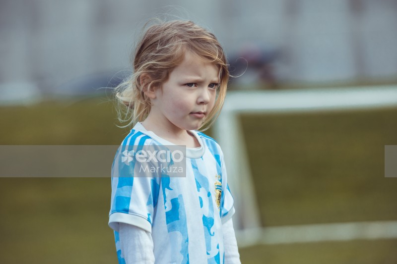 Blue and white striped kit wearing girl at Little Dribblers football match