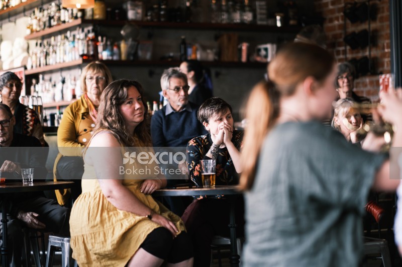 Group of people watching a performance at a bar
