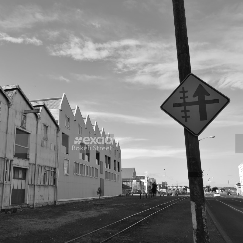 Warehouses and railway crossing sign at Hawkes bay black and white