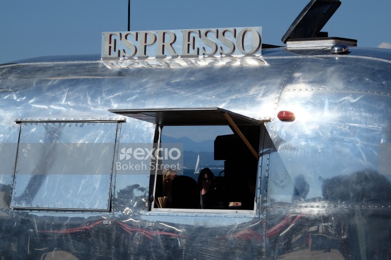 Espresso chrome coffee truck and a yatch in the distance
