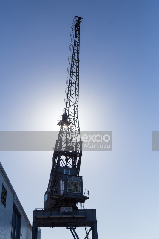 Tall crane against the sun