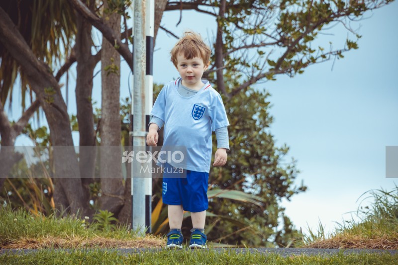 Kid in England kit standing on a pathway - Little Dribblers