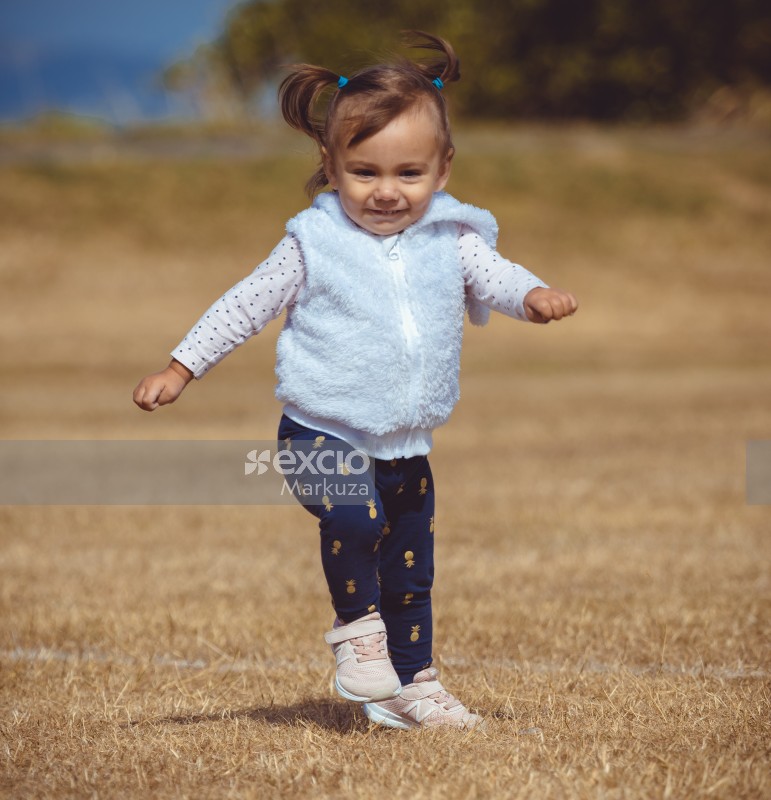 Little girl in furry sleeveless jacket running - Little Dribblers