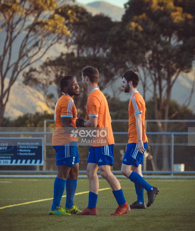 Football teammates in orange shirts Adidas - Sports Zone sunday league