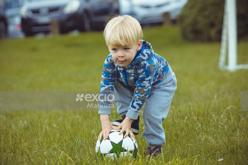 Blonde kid with camouflage jacket stepping on a football - Little Dribblers