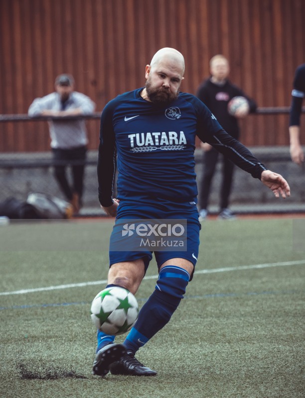 Bald football player in blue kit kicks ball - Sports Zone sunday league