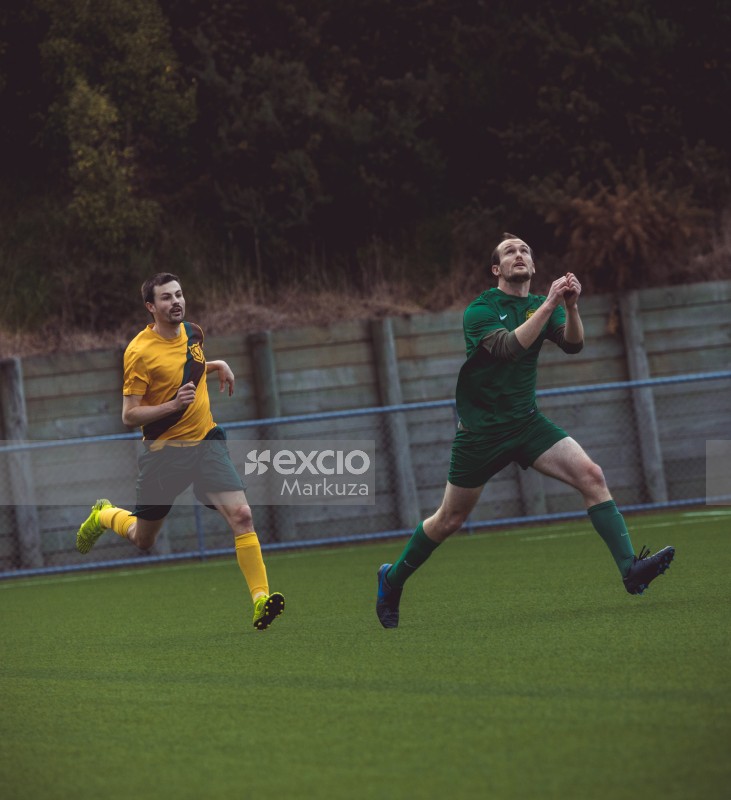 Player in green kit looking at an airborne football at Sports Zone sunday league soccer match