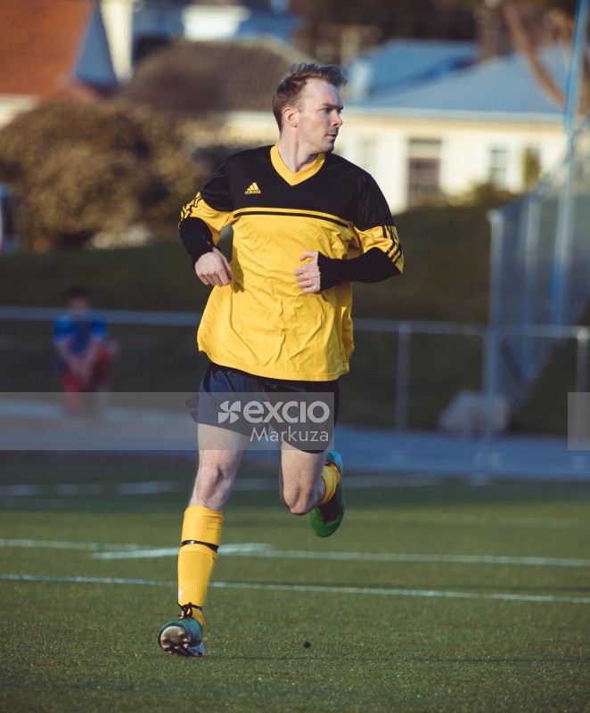 Football player looking to the side while running - Sports Zone sunday league
