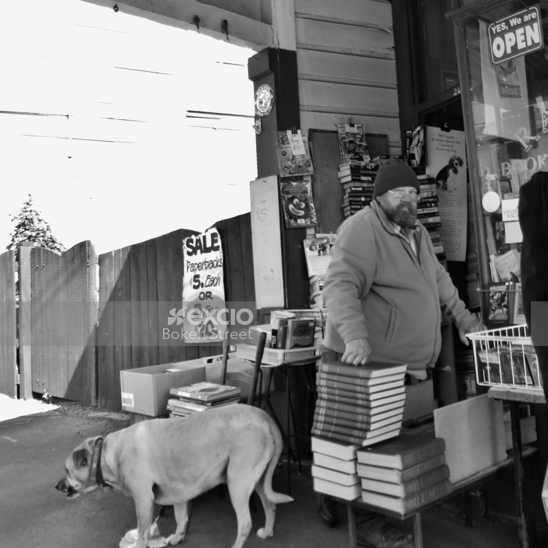 Guy with books and a dog black and white