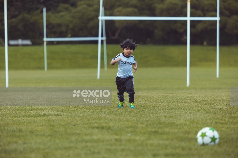 Kid running on grass at Little Dribblers soccer match